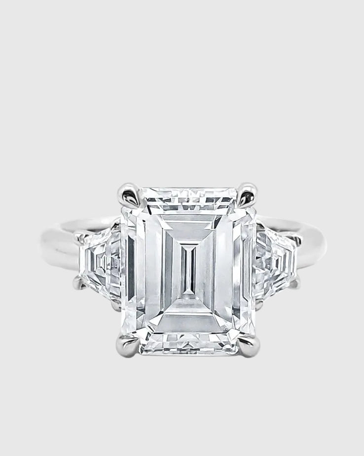 Top-down view of the Majesté ring, showcasing the perfectly symmetrical 'hall of mirrors' effect of the 5-carat emerald-cut moissanite and its side baguettes.