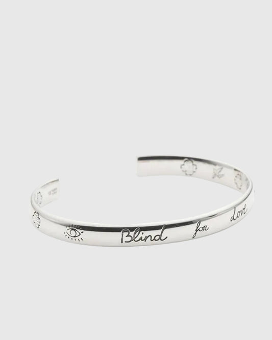 Silver bracelet with engraved text on a white background.