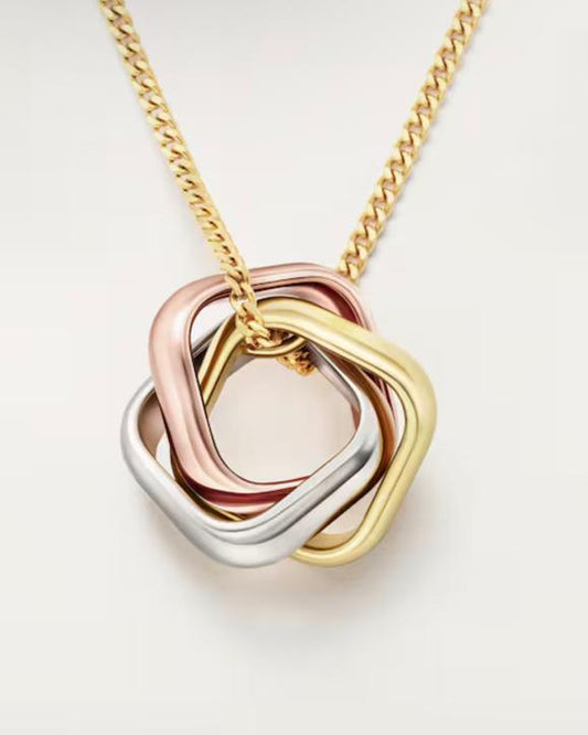 Angled studio view of the modern Harmonie Trio pendant, showcasing the architectural soft-square, cushion-shaped intertwining rings in 18K white, rose, and yellow gold plating.