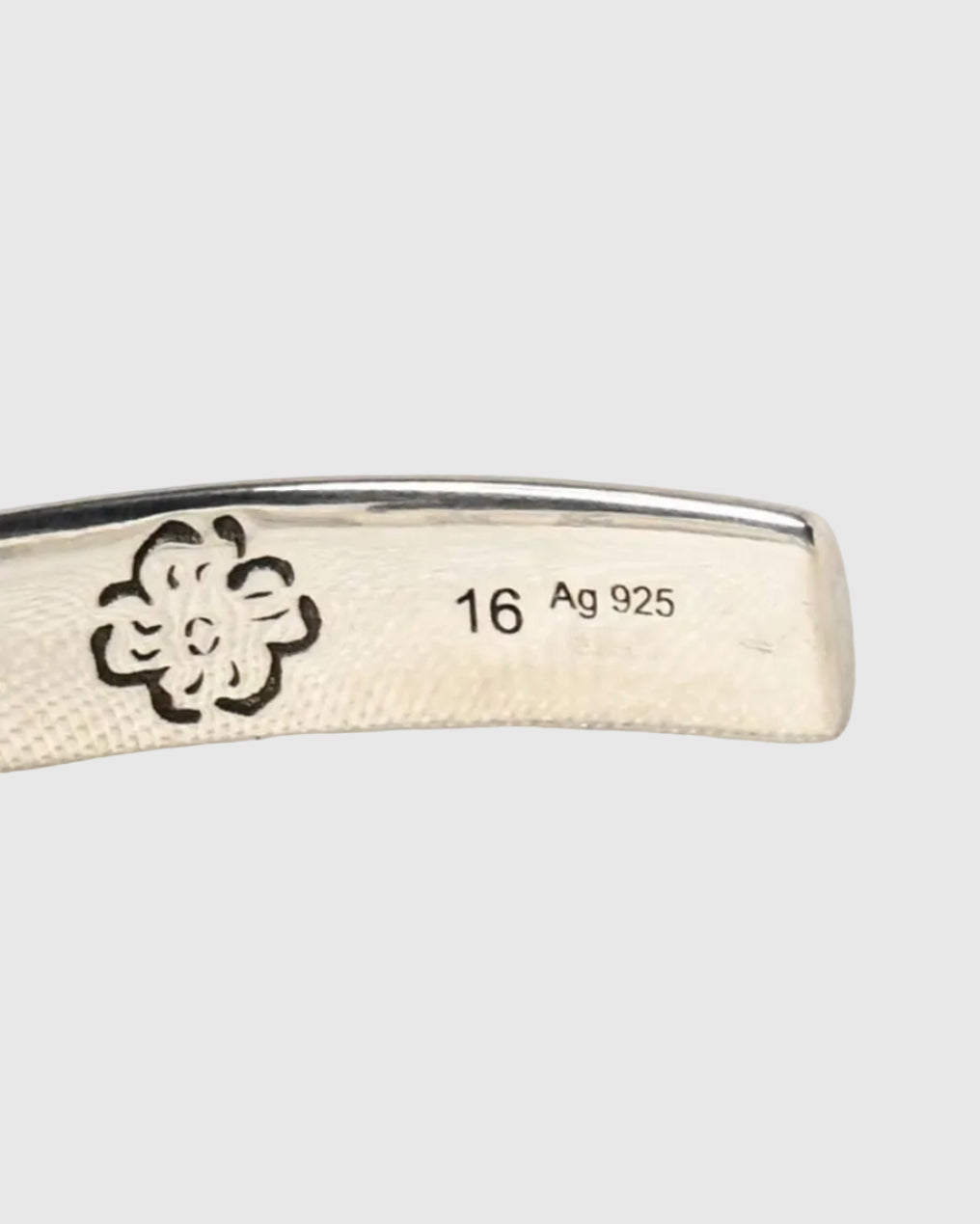 An expressive cuff featuring the hand-engraved “Blind for Love” motif with a white background