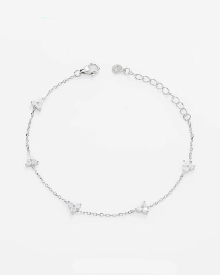 Top-down flat view of the Fiorella platinum-plated 925 sterling silver station bracelet, showcasing perfectly spaced four-petal moissanite flower charms.