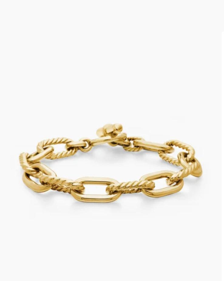 Angled view of the Claspéra Madison gold-plated sterling silver bracelet, demonstrating the heavy, substantial feel of the 11mm architectural links.