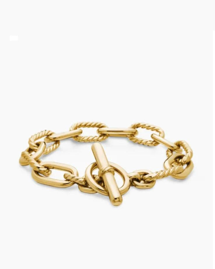 Angled view of the Claspéra Madison gold-plated sterling silver bracelet, demonstrating the heavy, substantial feel of the 11mm architectural links.