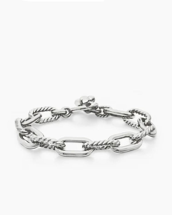 Angled view of the Claspéra Madison rhodium-plated sterling silver bracelet, demonstrating the heavy, substantial feel of the 11mm architectural links.