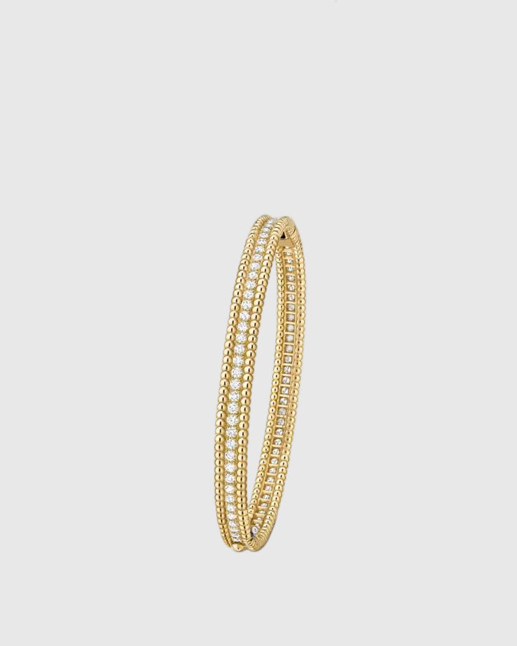 Angled studio view of the Lumina Perlina 18K gold-plated solid silver bangle, highlighting the iconic beaded contour flanking a single row of VVS1 moissanite stones.