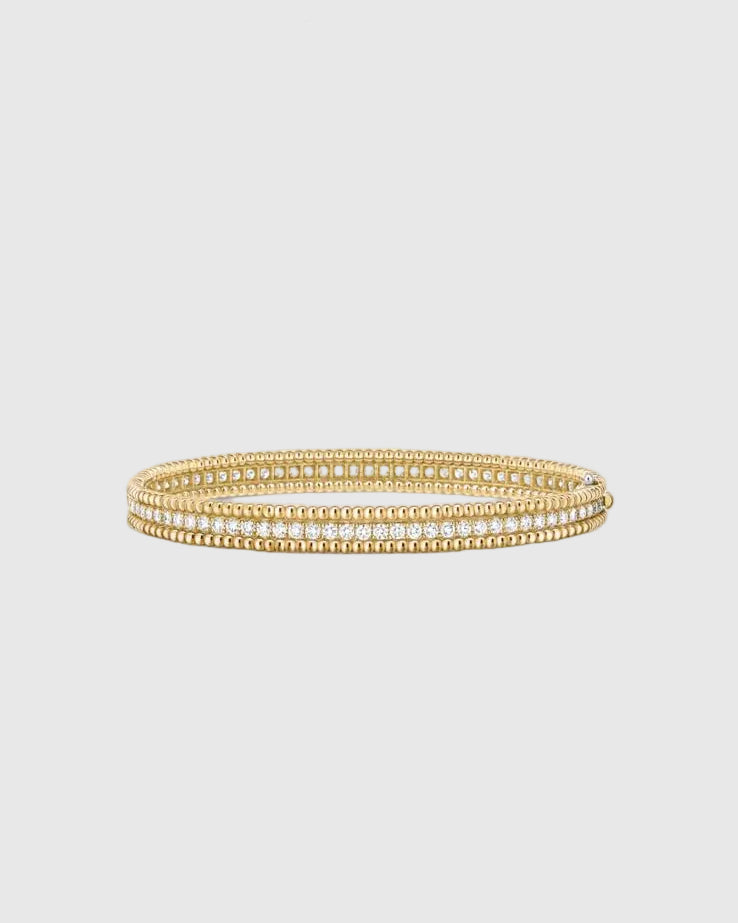 Angled studio view of the Lumina Perlina 18K gold-plated solid silver bangle, highlighting the iconic beaded contour flanking a single row of VVS1 moissanite stones.