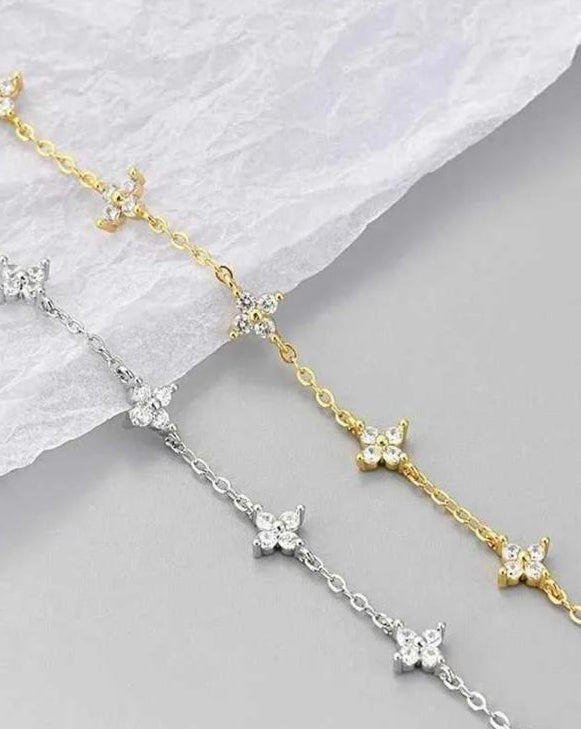 Studio shot showing both the 18K gold-plated and platinum-plated variations of the Fiorella 925 silver bracelet, highlighting the 0.6ct 3EX moissanite floral motifs.