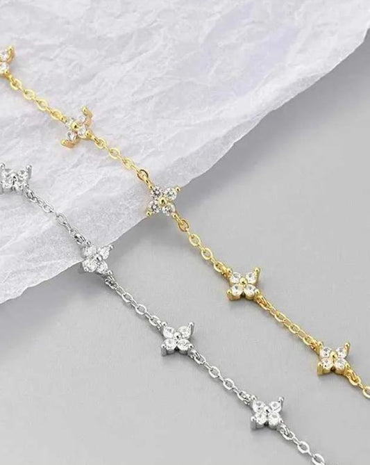 Studio shot showing both the 18K gold-plated and platinum-plated variations of the Fiorella 925 silver bracelet, highlighting the 0.6ct 3EX moissanite floral motifs.