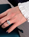 A sophisticated woman modeling the Aerion Imperia 4-carat princess-cut lab-grown diamond three-stone ring on her hand, highlighting the massive 10x10mm center stone.