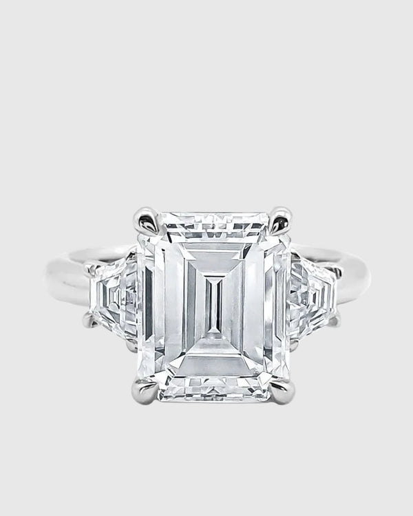 Top-down view of the Majesté ring, showcasing the perfectly symmetrical 'hall of mirrors' effect of the 5-carat emerald-cut moissanite and its side baguettes.