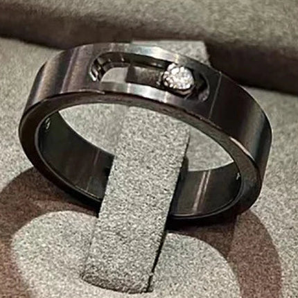 Black ring with a diamond on a textured surface