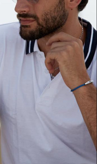 Man wearing An adjustable cuff bracelet with blue plating and a sleek wire design, featuring a lobster clasp. on a boat.