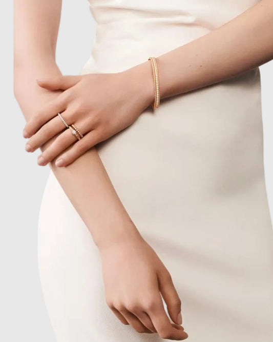 A close-up shot of a sophisticated woman's hand modeling the Lumina Perlina solid 925 silver beaded eternity bangle, showcasing the 2.16-carat moissanite brilliance.