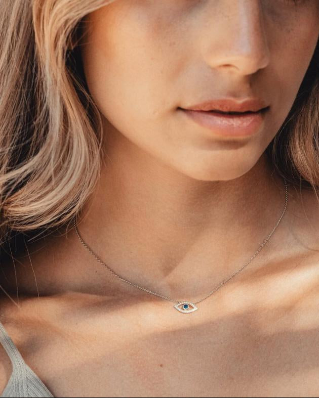 A sophisticated woman, wearing the Auréveil Oculus solid 925 silver protective talisman necklace featuring a 1-carat black moissanite center stone.