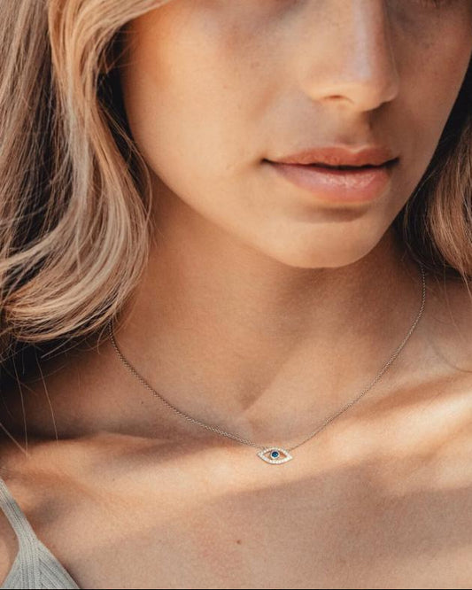 A sophisticated woman, wearing the Auréveil Oculus solid 925 silver protective talisman necklace featuring a 1-carat black moissanite center stone.