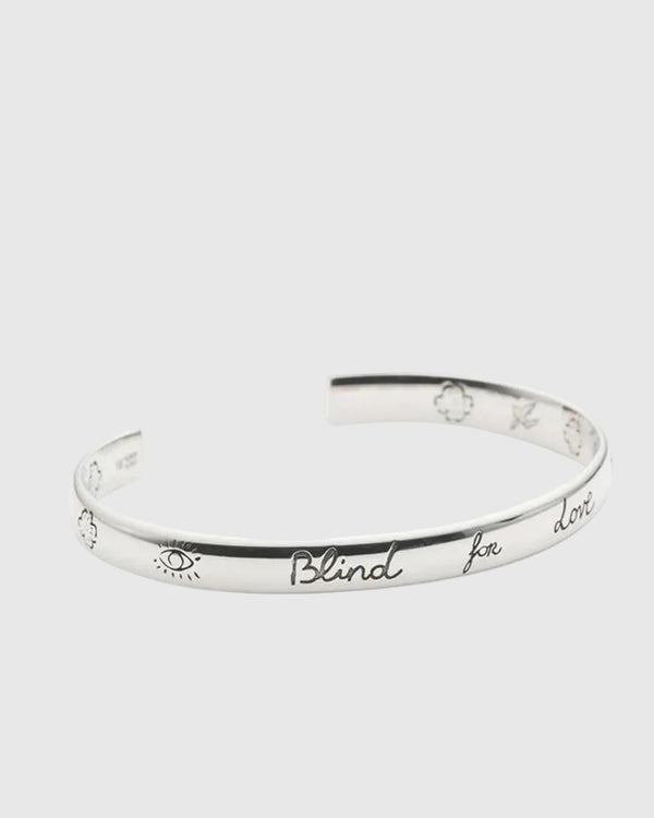 Silver bracelet with engraved text on a white background.