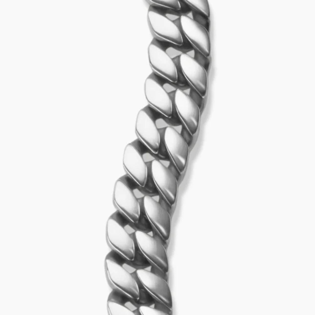 Close-up of a silver Curb Chain Bracelet on a plain background