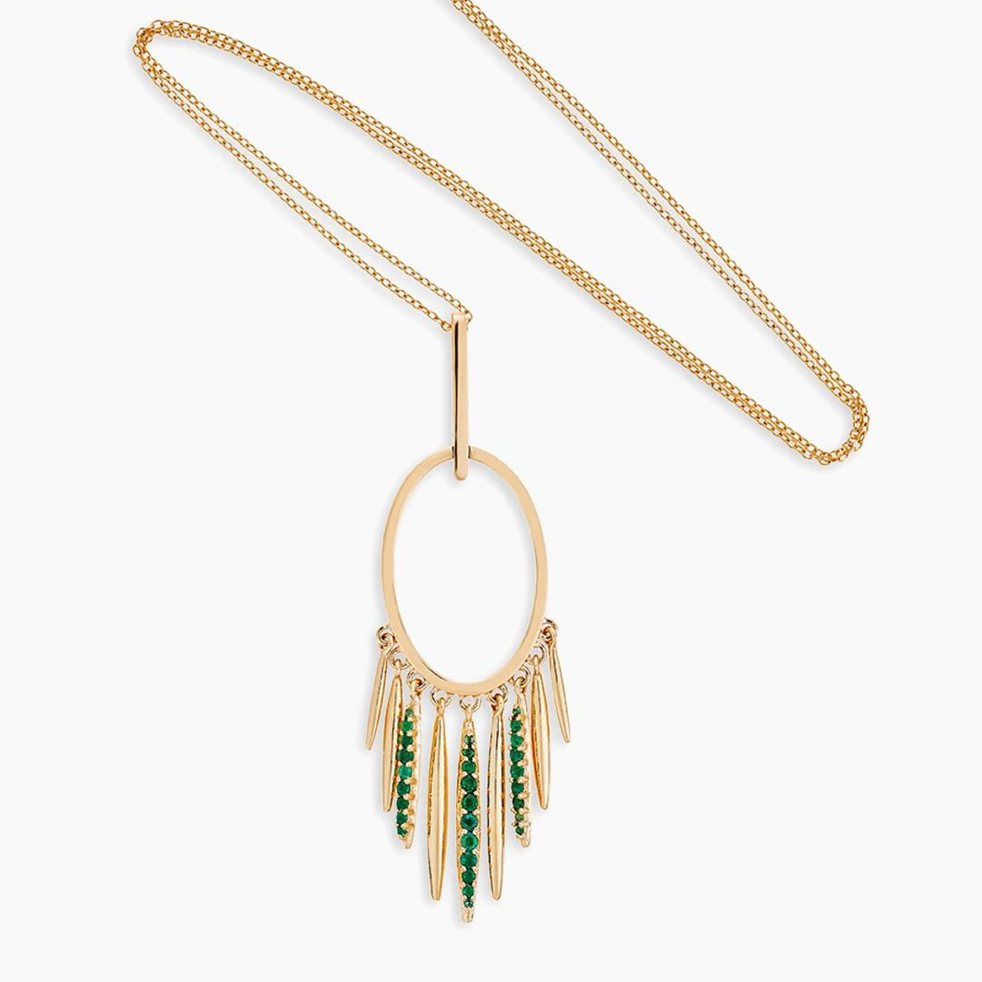 Gold necklace with green gemstone pendant on a white background