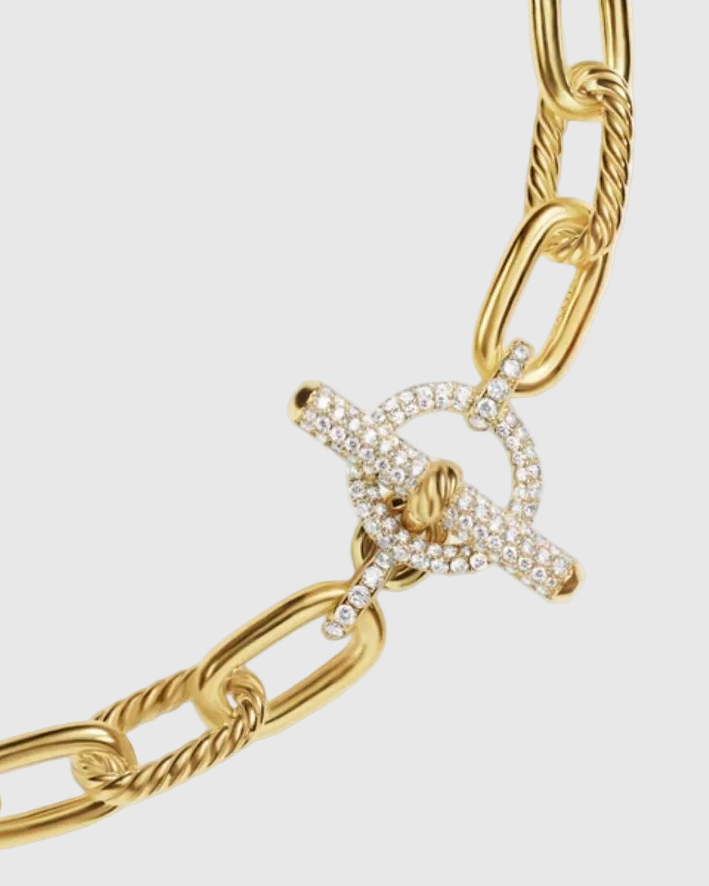 Macro detail of the 925 solid silver chain gold plated, emphasizing the flawless high-mirror polish on the smooth links and the intricate texture of the twisted cable links.background