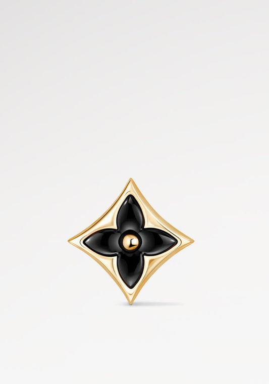 Gold and black Star Ear Stud on a light gray background