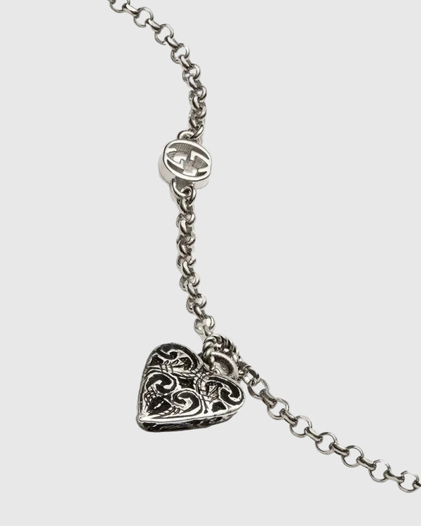 Aerion Cuore 925 sterling silver chain bracelet featuring interlocking monogram charms and an ornately engraved vintage heart pendant.