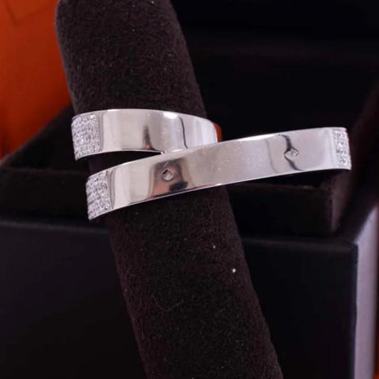 Silver ring with diamond accents on a black stand