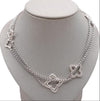 Silver necklace with butterfly designs on a gray stand