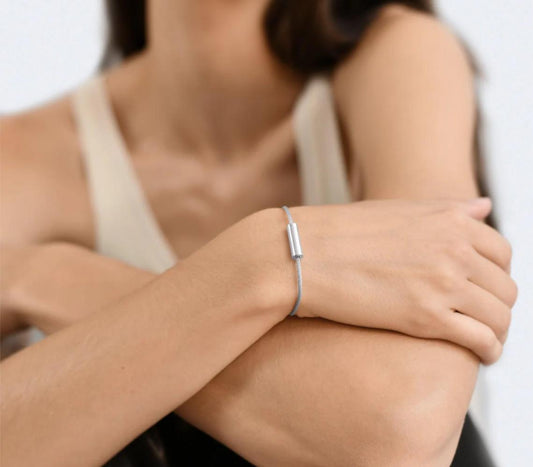 Woman wearing a silver bracelet on a plain background