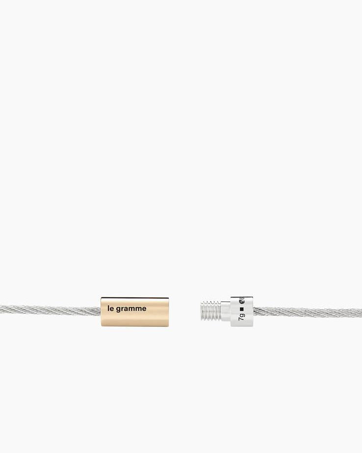 Silver bracelet with a gold tag labeled 'legram' on a white background
