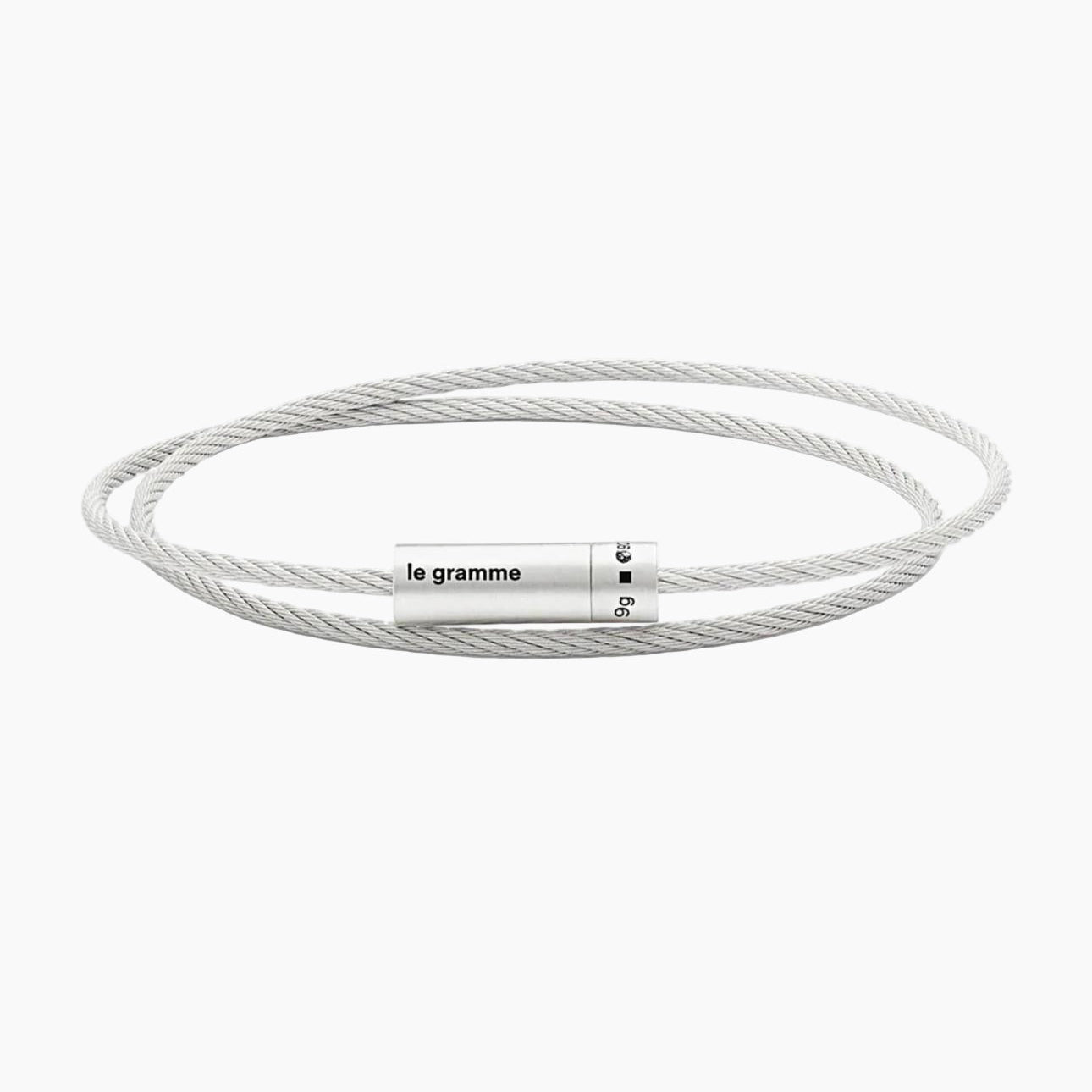 Silver cable bracelet with a cylindrical tag on a white background