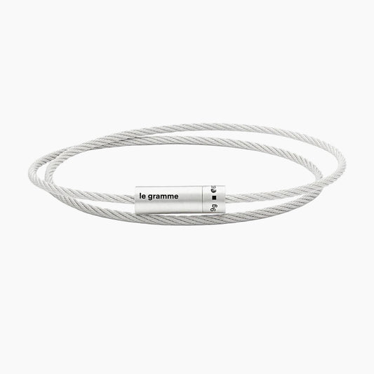 Silver cable bracelet with a cylindrical tag on a white background