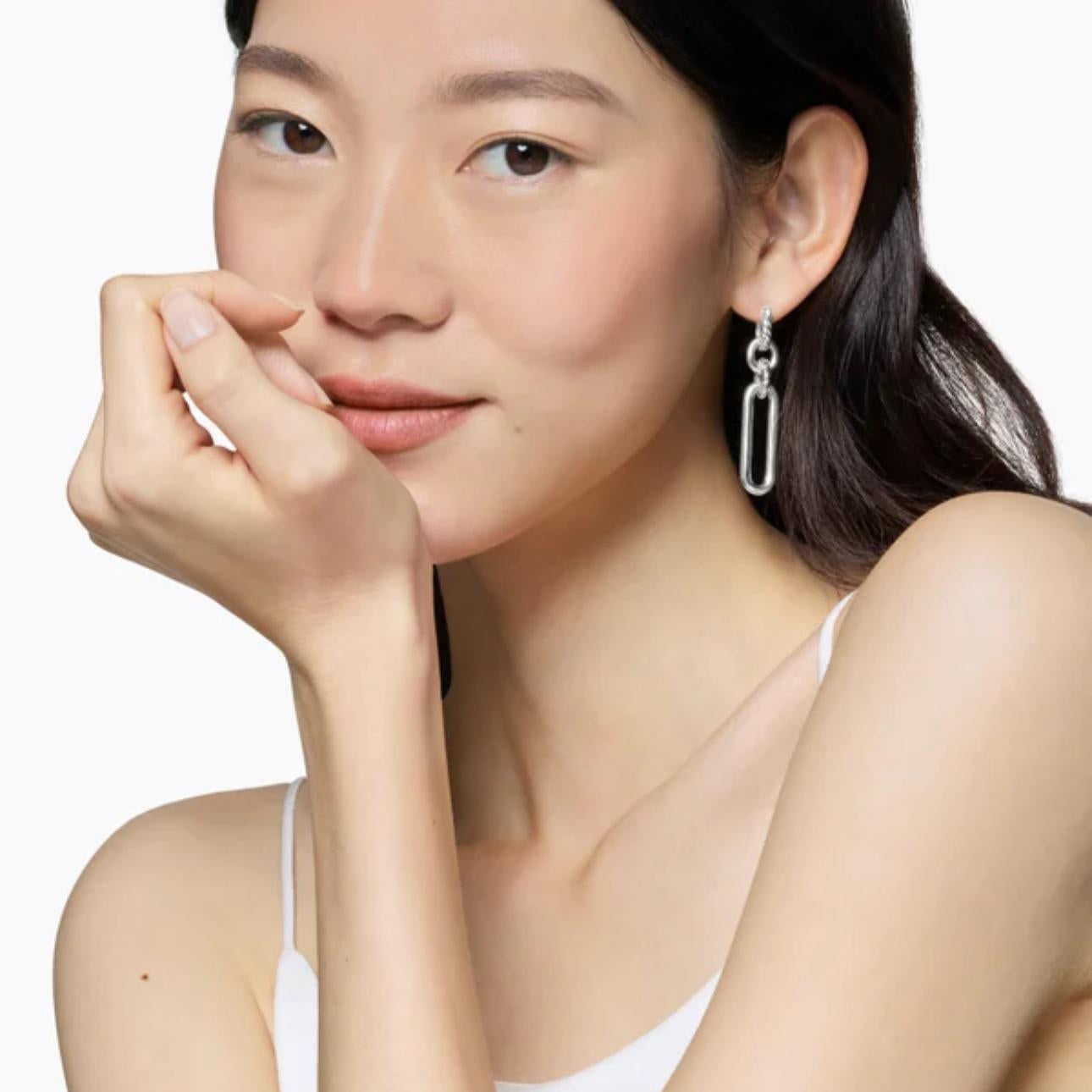 Woman wearing a DROP EARRINGS with a plain background