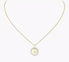 Gold necklace with a round pendant on a white background