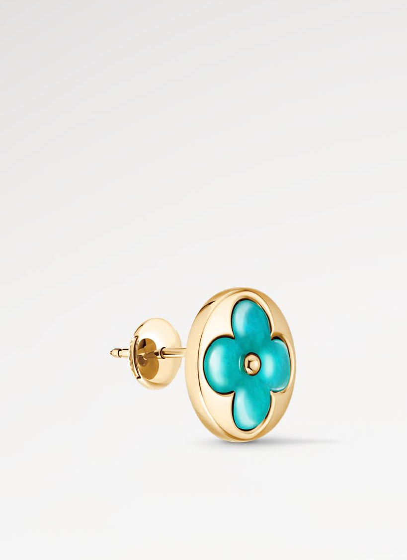 Gold earring with turquoise flower design on a light gray background