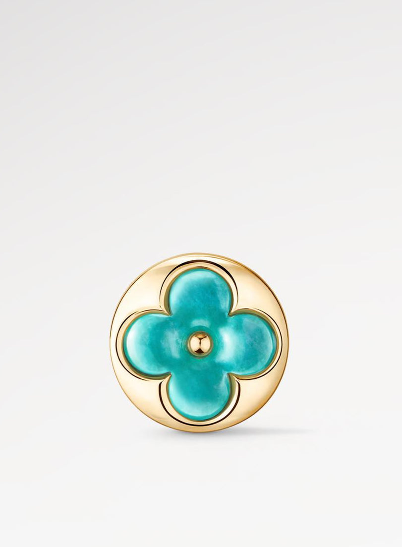 Turquoise flower-shaped earring with gold frame on a light gray background