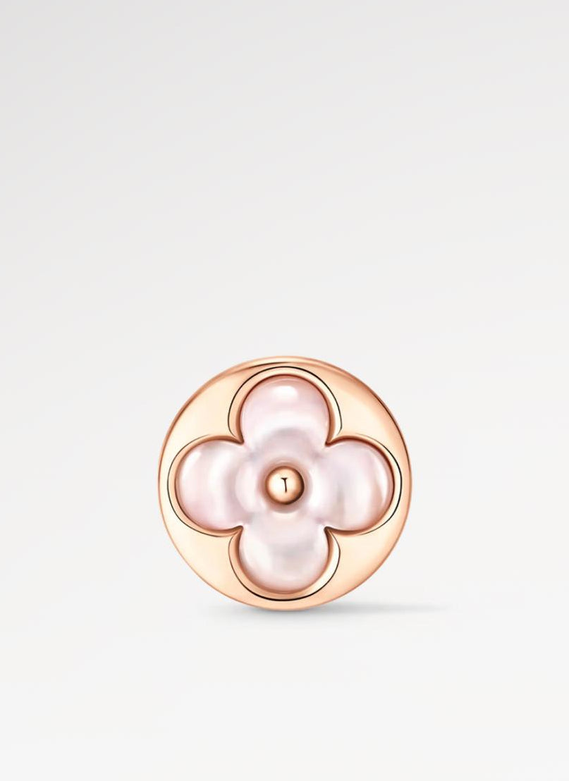 Rose gold earring with a central pearl on a light gray background