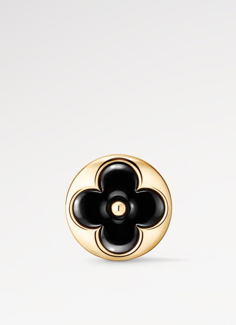 Gold and black floral earring on a light gray background