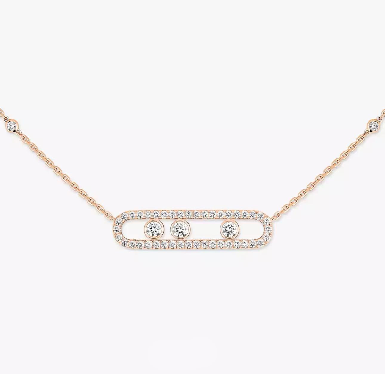 Rose gold necklace with three diamond-like stones on a light gray background