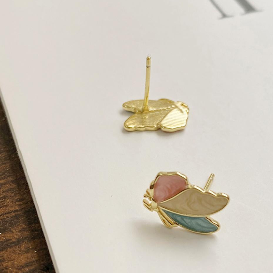 Gold earrings with pink and blue stones on a white surface
