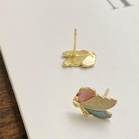 Gold earrings with pink and blue stones on a white surface