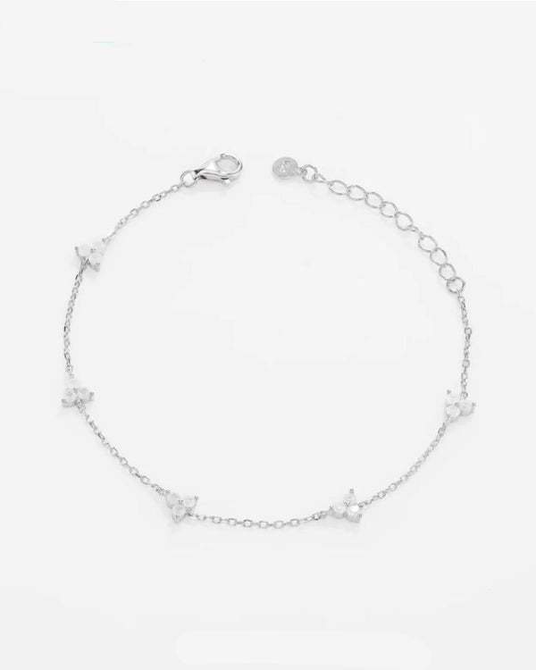 Top-down flat view of the Fiorella platinum-plated 925 sterling silver station bracelet, showcasing perfectly spaced four-petal moissanite flower charms.