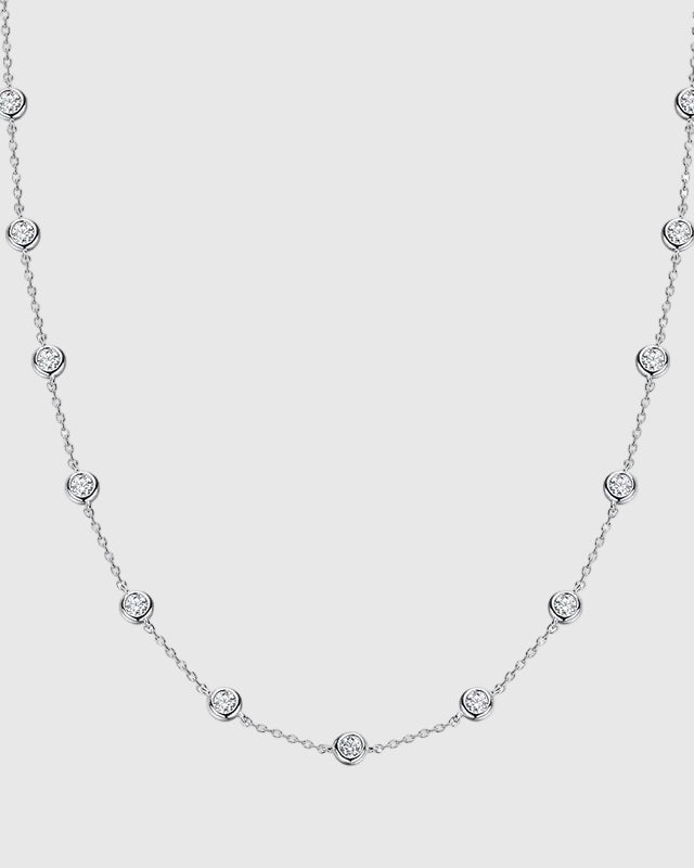 Full studio view of the Auréclaire 2-carat moissanite station necklace in premium platinum-plated 925 sterling silver, highlighting the flawless D-color VVS bezel-set stones.