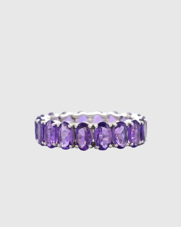 Front profile of the minimalist platinum-polished silver eternity ring featuring a seamless setting of brilliant natural violet amethysts.