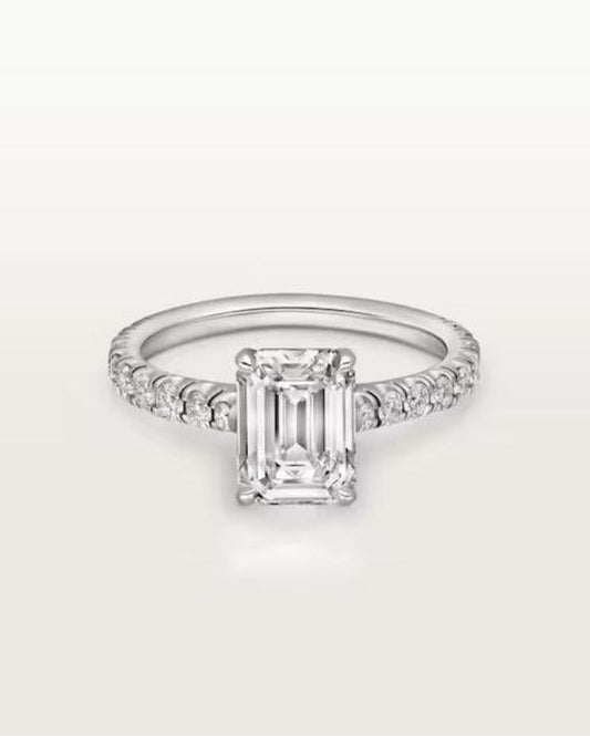 Angled studio shot of the flawless 4ct radiant-cut moissanite engagement ring, highlighting the brilliant U-cut half-eternity pavé band and 4-claw prong setting.