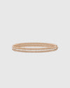 Angled studio view of the Lumina Perlina 18K rose gold-plated solid silver bangle, highlighting the iconic beaded contour flanking a single row of VVS1 moissanite stones.
