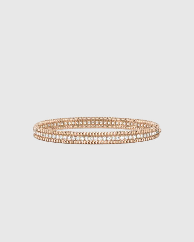 Angled studio view of the Lumina Perlina 18K rose gold-plated solid silver bangle, highlighting the iconic beaded contour flanking a single row of VVS1 moissanite stones.