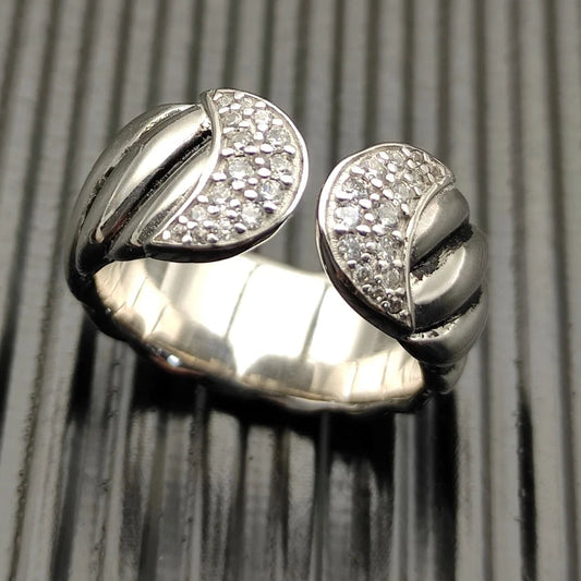 Silver ring with diamond accents on a textured surface