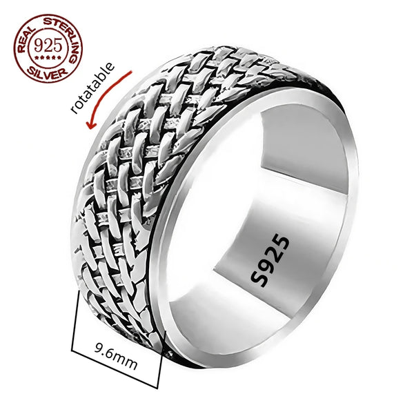 A silver spinner ring with Great Wall-inspired engravings on a double-layered band, displayed on a wooden texture background.