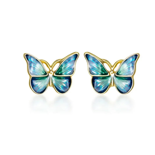 A pair of colorful butterfly stud earrings crafted from real 925 sterling silver, displayed on a beige fabric surface.