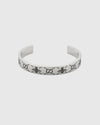 Elegant open cuff silver bracelet with engraved logo pattern, luxury minimalist bangle for women, high-end jewelry close-up